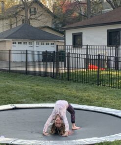 12ft Round Akrobat Primus Flat In-Ground Trampoline - Anthracite Grey (Grey Pad and Black Jump Mat) 9 child doing a trick on a gray round inground trampoline