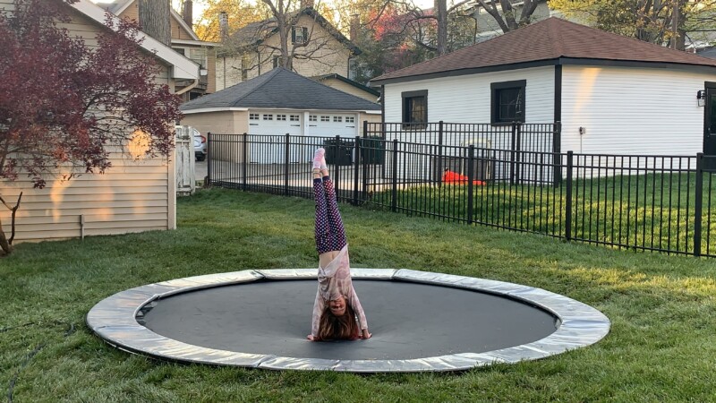 12ft Round Akrobat Primus Flat In-Ground Trampoline - Anthracite Grey (Grey Pad and Black Jump Mat) 2 child doing a trick on a gray round inground trampoline