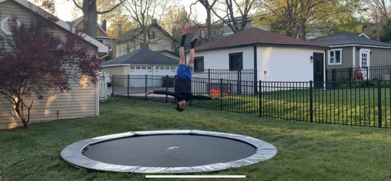 14ft Round Akrobat Primus Flat In-Ground Trampoline - Anthracite Grey (Grey Pad and Black Jump Mat) 2 child doing a trick on a gray round inground trampoline
