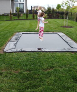 children jumping on black inground trampoline