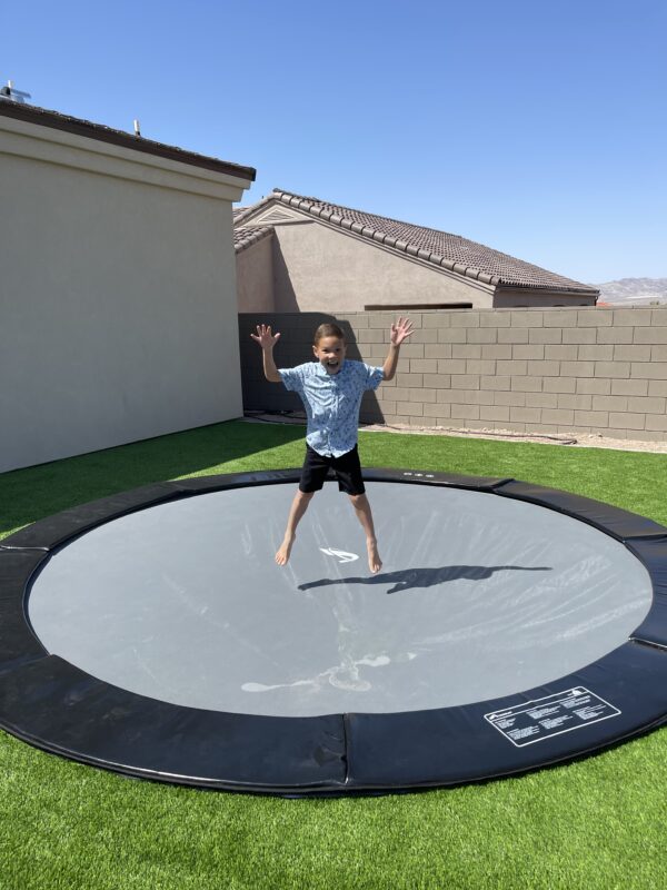 Trampoline Parts Explained | Akrobat 4 child jumping on a black round inground trampoline
