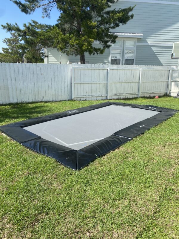 How Long Does It Really Take to Put Together a Trampoline? 4 A large rectangular pool in a backyard, accompanied by a trampoline, creating a fun outdoor recreational space.