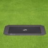 A black trampoline located on a lush green field, ideal for outdoor fun and exercise.