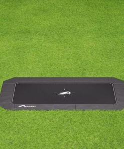 A black trampoline located on a lush green field, ideal for outdoor fun and exercise.